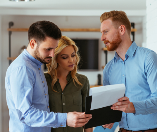 Three people reviewing health insurance documents